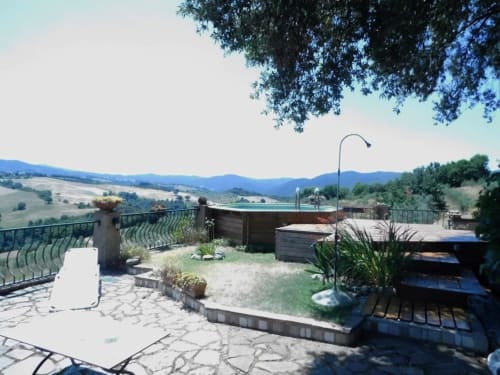 Terrasse des Agri-Bio Santa Palmira in Pomarance mit Infinity-Pool, Bergblick und toskanischer Landschaft