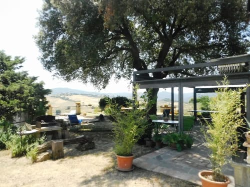Gartenterrasse im Agri-Bio Santa Palmira mit Pergola, Topfpflanzen und Blick auf die Toskana-Landschaft