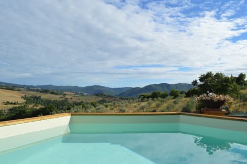 Infinity-Pool mit Blick auf die toskanischen Hügel bei Agri-Bio Santa Palmira, Pomarance, Italien