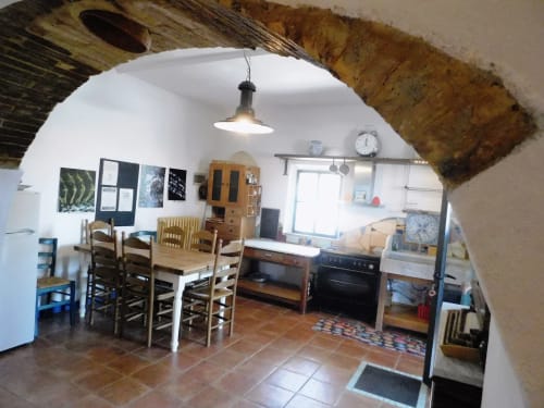 Rustikaler Küchen-Essbereich auf Agri-Bio Santa Palmira mit Holztisch, Stühlen und Küchengeräten