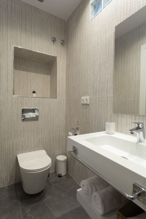 Baño moderno en el hostel Room Boutique 32 de Denia con lavamanos blanco, inodoro y ducha a ras de suelo