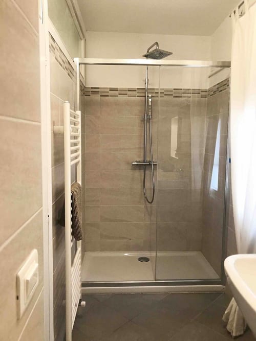 Modern glass shower enclosure in Ca Corrigiane Venice apartment bathroom with heated towel rack