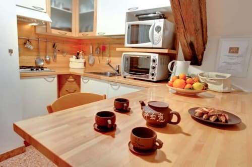 Cucina della Ca Cortigiane Suite con tavolo da pranzo, angolo caffè e elettrodomestici a Venezia