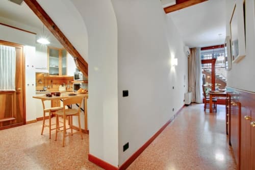 Suite Ca Cortigiane moderna a Venezia con cucina open-plan, travi in legno e ampia zona living con vista sulla città