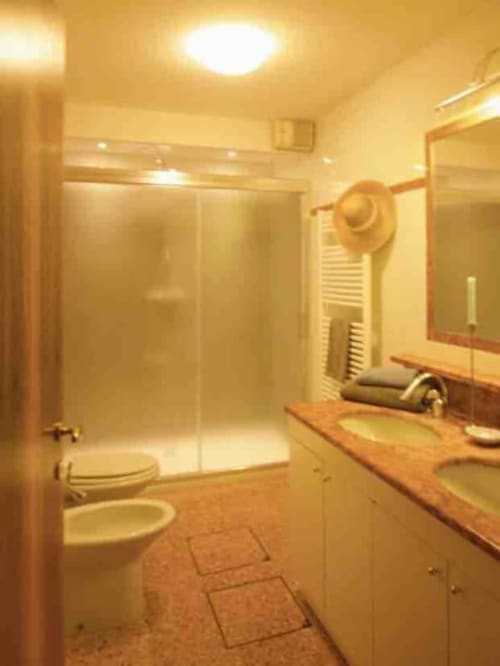 Bagno moderno della Ca Cortigiane Suite a Venezia con doccia in vetro, mobile lavabo in legno e illuminazione ambientale