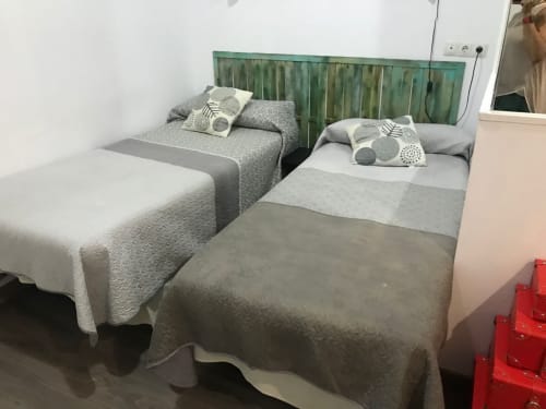 Dos camas individuales con colchas texturizadas grises y almohadas decorativas en Apartamentos Huelintown, Málaga