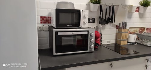 Cocina moderna en Apartamentos Huelintown Málaga con microondas, horno y almacenamiento organizado en la encimera