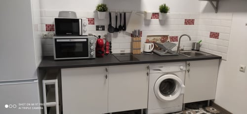 Moderna cocina en apartamento Red de Huelintown Málaga con microondas, horno, lavadora y fregadero