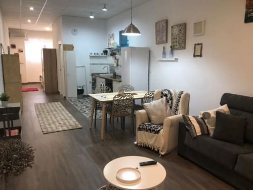 Sala de estar moderna en Apartamentos Huelintown, Málaga con mobiliario actual, comedor y cocina equipada