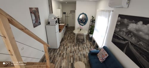 Cocina y sala de estar modernas en Apartamentos Huelintown de Málaga con televisor, zona de descanso y vista al jardín