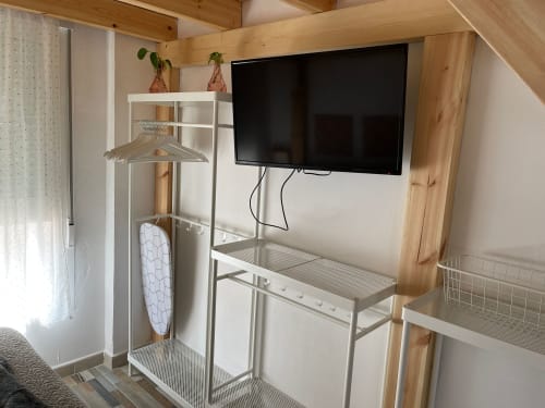 Acogedora habitación en Apartamentos Huelintown, Málaga con TV de pantalla plana, perchero y mobiliario moderno