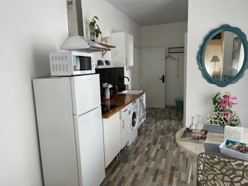 Cocina moderna del apartamento Huelintown en Málaga con electrodomésticos blancos y encimeras de madera