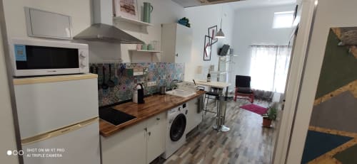 Moderna cocina y sala de estar en Apartamentos Huelintown, Málaga con microondas, lavadora y colorida decoración