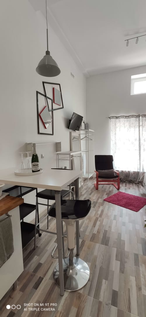 Moderno estudio en Málaga con mesa de comedor, cocina americana, iluminación colgante y mobiliario contemporáneo