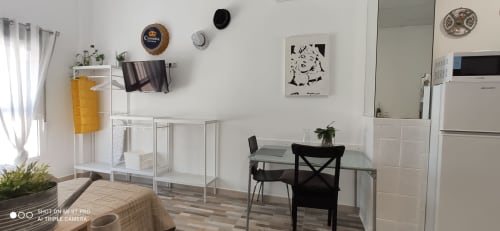 Estudio moderno en Apartamentos Huelintown, Málaga con comedor, TV, cocina y decoración minimalista