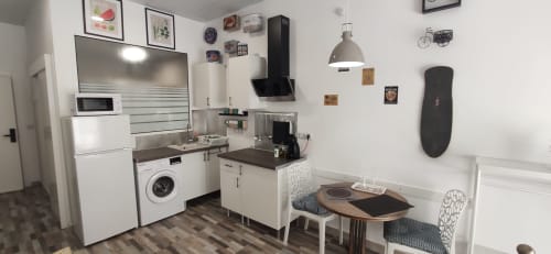 Cocina moderna en Apartamentos Huelintown Málaga con electrodomésticos blancos, comedor y decoración mural