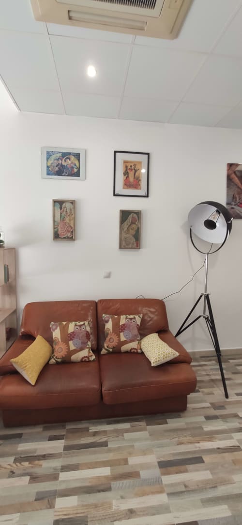 Acogedor estudio en Málaga con sofá de cuero óxido, arte decorativo, lámpara de trípode y aire acondicionado moderno