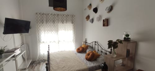 Luminoso dormitorio en Apartamentos Huelintown, Málaga, con cama doble, TV, cortinas estampadas y vista al jardín