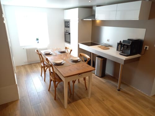 Cuisine ouverte et salle à manger modernes de l'appartement Moulin de la Chevanne avec table en bois et placards blancs
