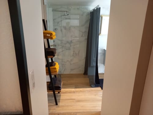 Salle de bain moderne avec douche à l'italienne vitrée à l'appartement Moulin de la Chevanne à Champlive, parquet bois