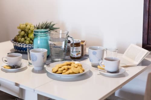 Welcome refreshments at Ca Cortigiane Venice apartment: coffee, snacks, water, and grapes on table