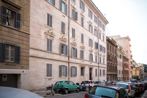 Facciata esterna di Petra Apartments Roma con auto parcheggiate su una storica via italiana
