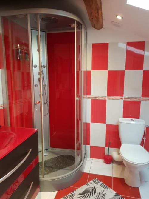 Salle de bain moderne aux carreaux rouge et blanc avec douche arrondie à la Chambre D'hôte Le Pommier de Clussais-la-Pommeraie