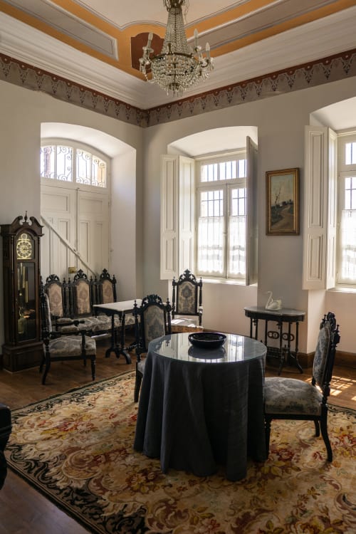 Elegant parlor at La Venta de Miyares with crystal chandelier, ornate black furniture, and arched windows