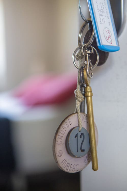 Clé d'hôtel avec étiquette numérotée et sifflet en laiton attachés au porte-clés de La Maison De Siloe B&B à Villefranche de Rouergue