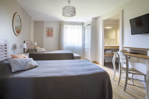 Chambre spacieuse à La Maison De Siloe B&B à Villefranche de Rouergue avec deux lits, télévision et salle de bain attenante