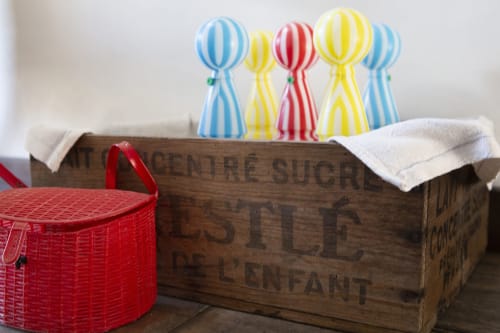 Caisse en bois vintage et panier rouge en osier avec décorations en papier rayé à La Maison De Siloe, Villefranche de Rouergue