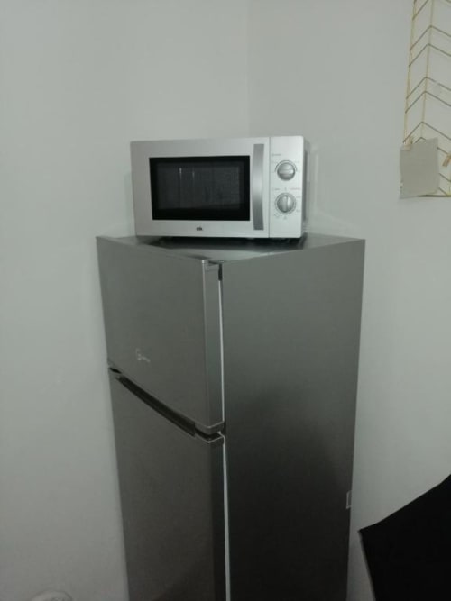 Forno a microonde bianco su frigorifero grigio nella cucina dell'appartamento Newhouse, Bari Italia