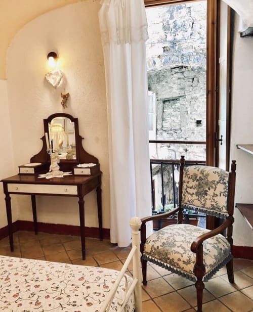 Chambre de l'Appartement Casté à l'Agritourisme Stecadò, Dolceacqua, avec coiffeuse ancienne, chaise en bois et pierre de caractère