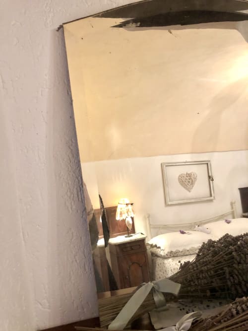 Chambre douillette de l'Appartement Casté à l'Agritourisme Stecadò, Dolceacqua, avec lit, lampe de chevet, œuvre cœur et décor rustique