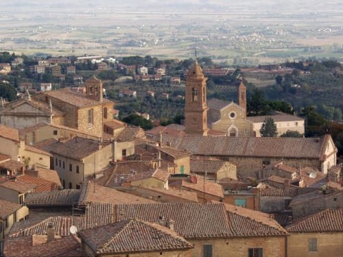 Montepulciano, borgo collinare con tetti in cotto, torri campanarie e campagna toscana ondulata presso La Locanda del Vino