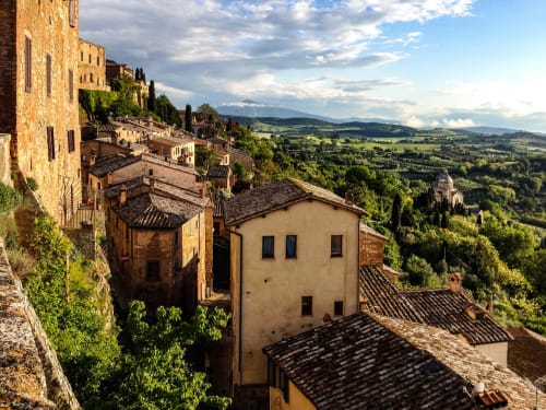 Montepulciano medievale che domina la campagna toscana con tetti in terracotta e cipressi
