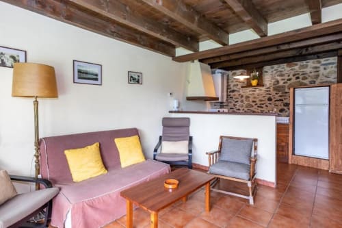 Sala de estar rústica en Torre Gelbert, Puigcerdà, con sofá rosa, vigas de madera y vistas a las montañas