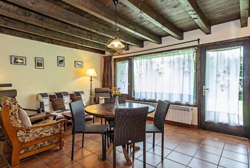 Amplio salón de la villa Torre Gelbert en Puigcerdà con vigas vistas, comedor y vistas a la montaña