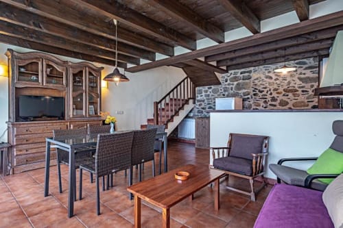 Villa Torre Gelbert en Puigcerdà con muros de piedra rústica, vigas vistas, comedor y vistas a la montaña