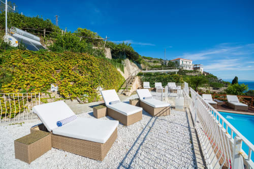 Terrazza lussuosa di Villa Costanza sulla Costa Amalfi con lettini, piscina e vista sul Mar Mediterraneo a Maiori, Italia