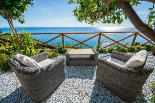 Terrazza villa costiera con lettini in vimini, ringhiera con vista mare e atmosfera mediterranea su Maiori, Costiera Amalfitana