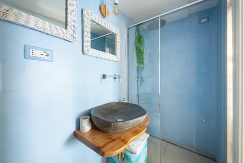 Bagno moderno con lavabo in pietra su mobile in legno, doccia a cascata, piastrelle blu e specchio a Villa Costanza, Costiera Amalfitana