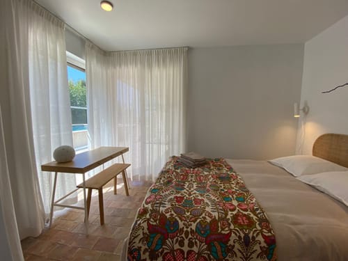 Chambre lumineuse à la Campagne d'Albert à Marseille avec vue sur la piscine, lit, bureau et accès au balcon
