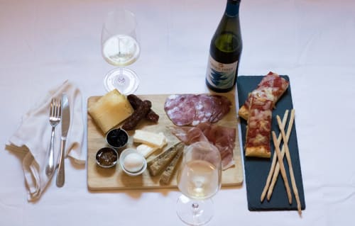 Elegante abbinamento di salumi e vini a Porta Tosa Milano, con carni stagionate, formaggi e vino bianco