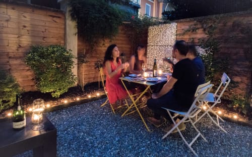 Cena serale nel cortile del B&B Porta Tosa a Milano, ospiti seduti a tavola sotto le calde luci decorative