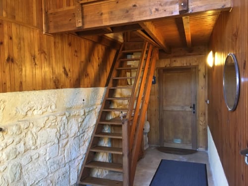 Couloir rustique en bois à la Sous Les Marronniers avec murs de pierre, échelle de mezzanine et poutres apparentes