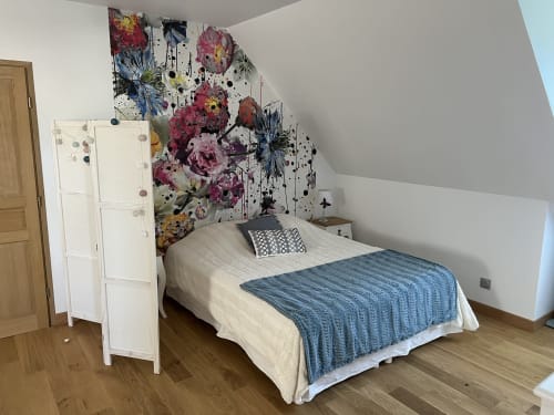 Modernes Schlafzimmer im Château Ségot mit farbenfrohem Blumenwandkunst, weißem Kleiderschrank und blauer Wurfdecke auf dem Bett