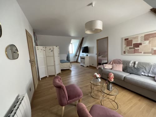 Das Studio im Château Ségot in Neuilly-le-Réal verfügt über einen modernen Wohnbereich mit grauem Sofa, burgunderfarbenen Sesseln und Zugang zu