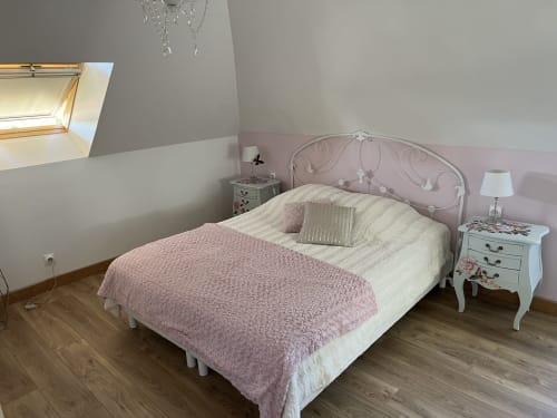 Das Studio-Schlafzimmer im Château Ségot in Neuilly-le-Réal mit einem Bett mit rosafarbener und cremefarbener Bettwäsche und weißen Nachttischen