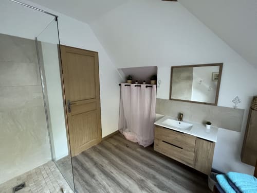 Modernes Badezimmer im Studio des Château Ségot mit offener Dusche, Holzwaschtisch und rosa Vorhang an der Badewanne